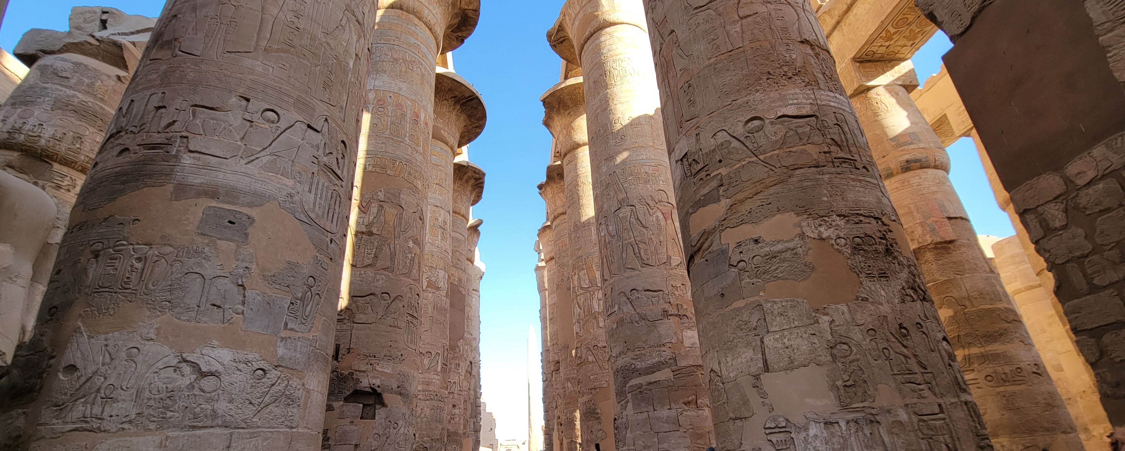 Looking up at the towering columns of Karnak's Great Hypostyle Hall, covered in hieroglyphics
