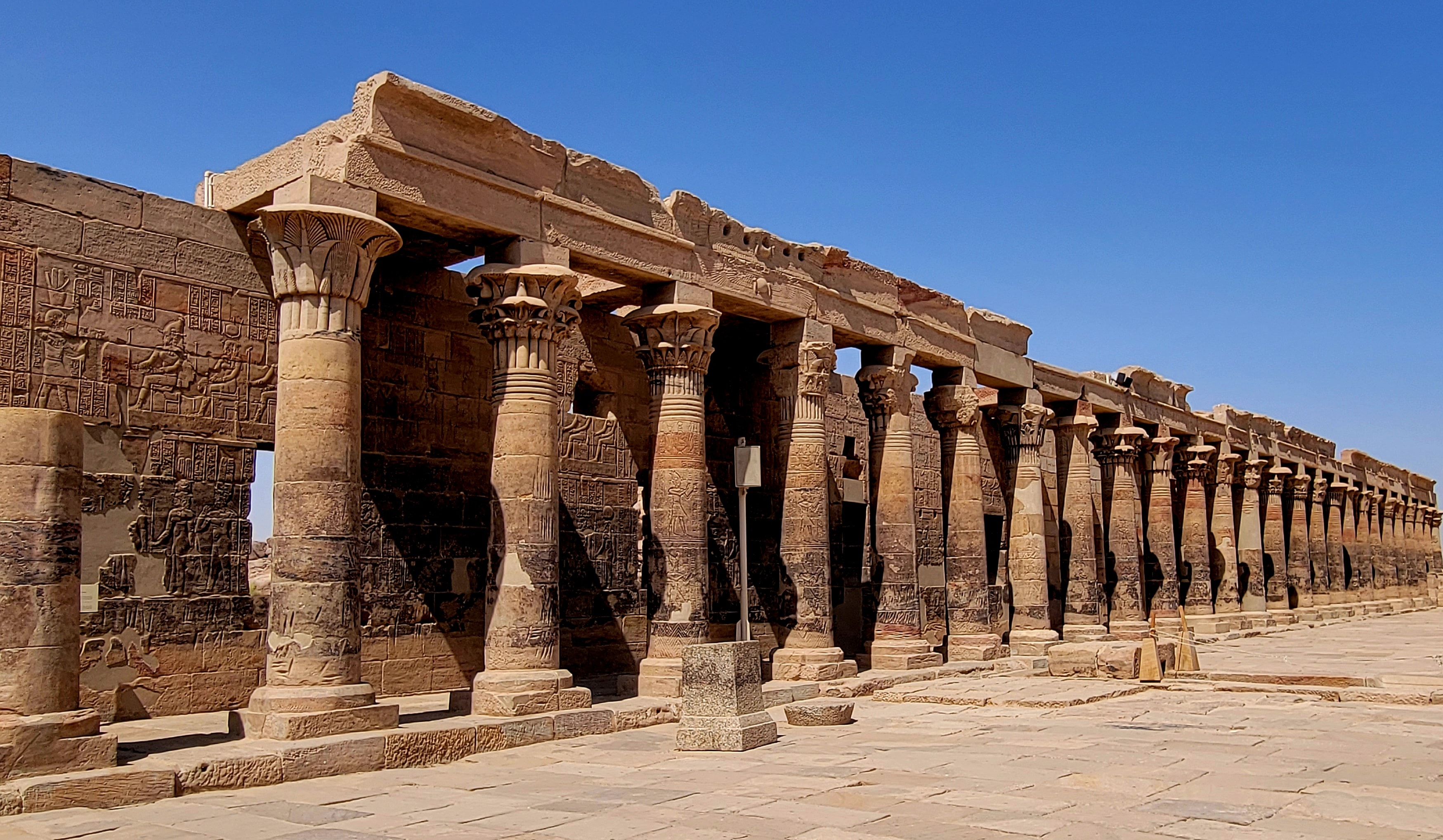 The colonnade of the Temple of Philae with vivid hieroglyphics carved into the stone columns